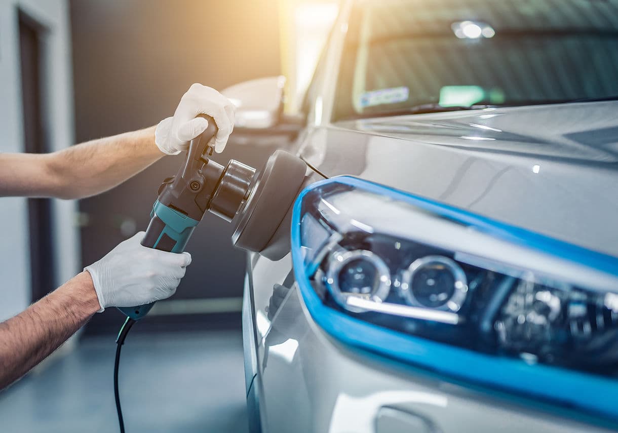 Technician buffing and polishing a car during collision repair